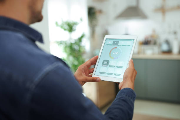 Propriétaire consultant son tableau de bord énergétique sur tablette